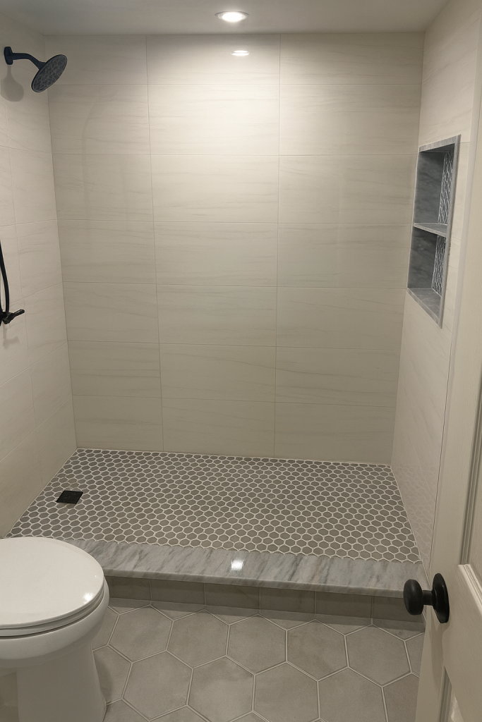 Completed neutral tile walk-in shower with niche and pebble floor by Luxe Revamp