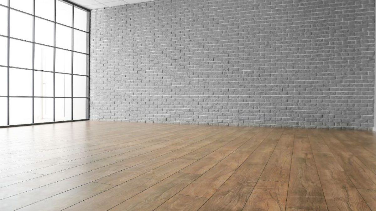 Wide-plank wood flooring in a modern open room with a large industrial-style window